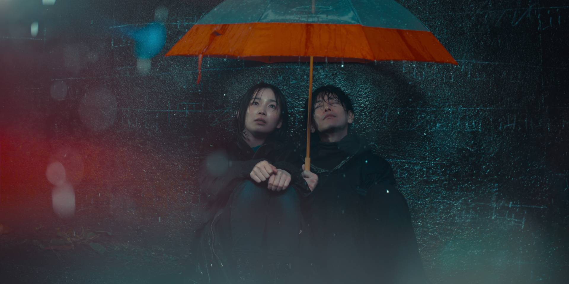 1つの傘に入って雨宿りする西条朱音（宮﨑優）と藤谷直季（佐藤健）