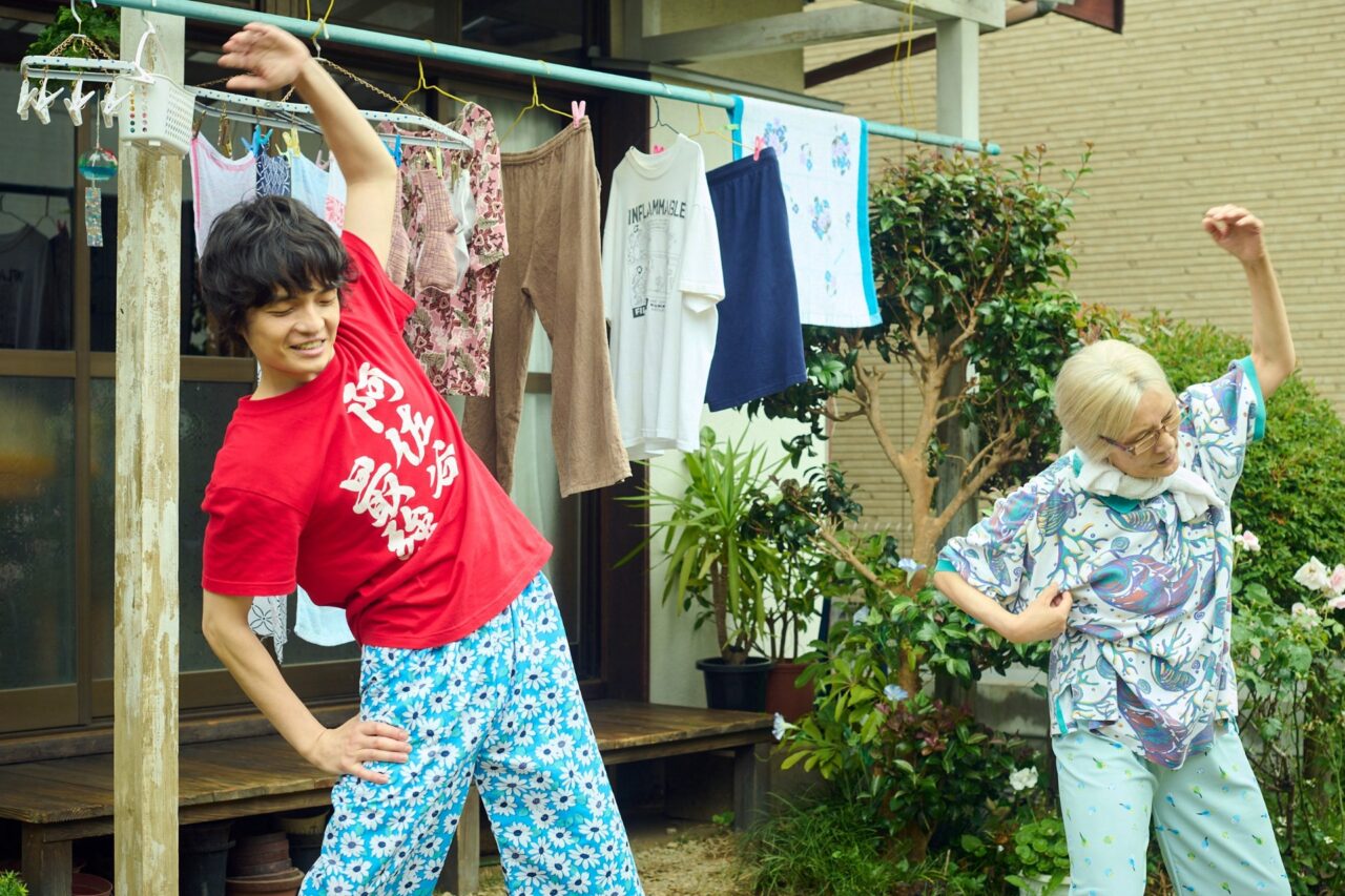 平屋の主・はなえ（根岸季衣）の日課であるラジオ体操に、並んで参加したヒロト©NHK